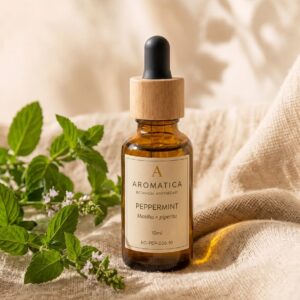以 10ml 琥珀色滴管瓶、亞麻布與暖米色背景構成，瓶子的右側有一堆新鮮的薄荷葉，葉子綠油油的，帶有鋸齒狀的邊緣。